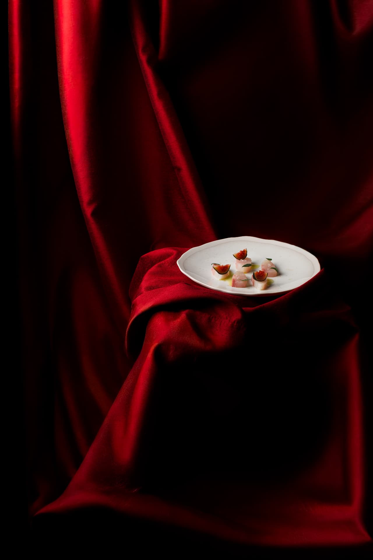 Pavés de thon aux figues posés sur un drap de satin rouge