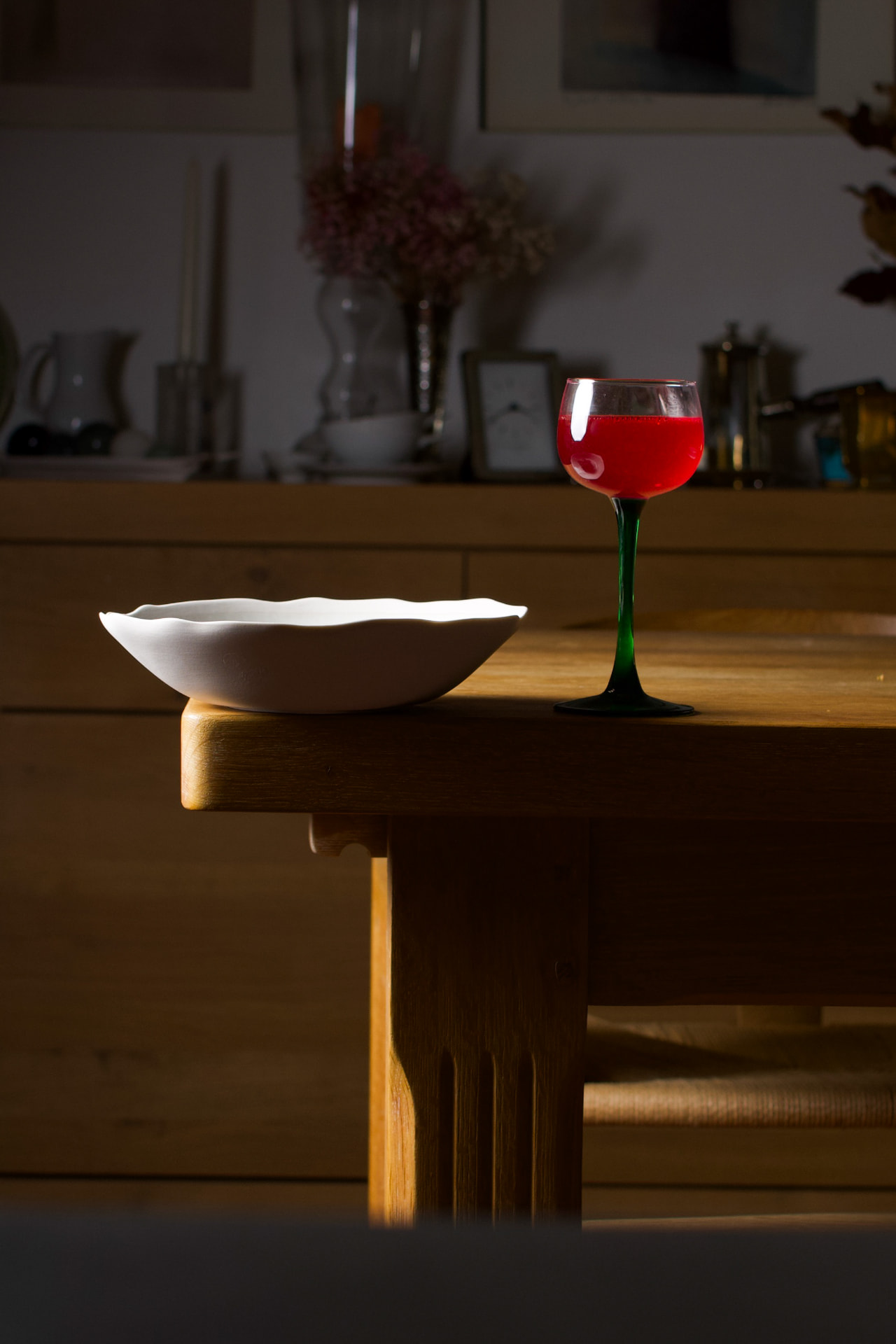Bol en grès et verre de rouge sur une table en bois