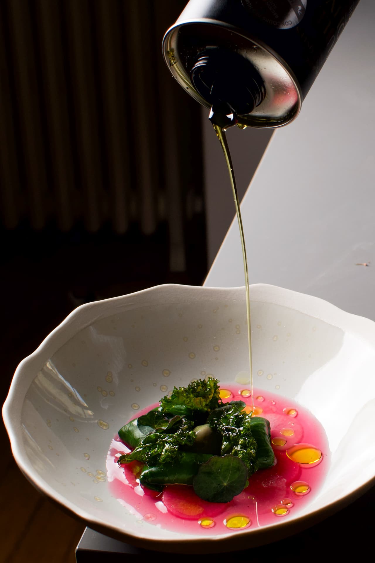 Huile d'olive versée sur un plat de légumes, sauce betterave rose