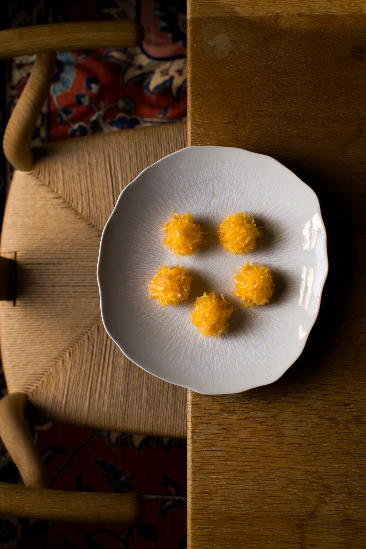 Beignets dorés dressés sur une assiette blanche ondée